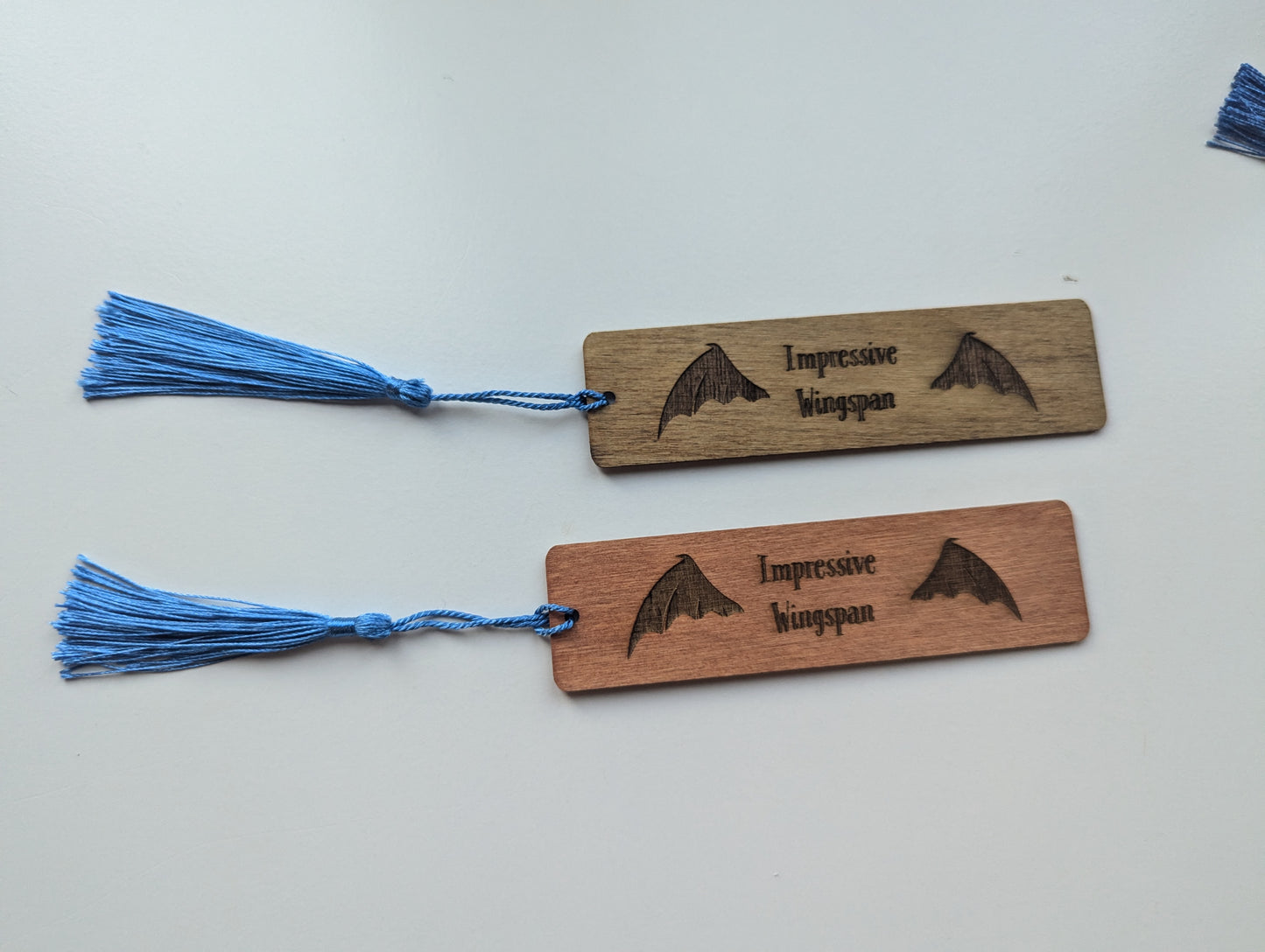 alt="Engraved wooden ACOTAR bookmark with quote 'Impressive Wingspan'"