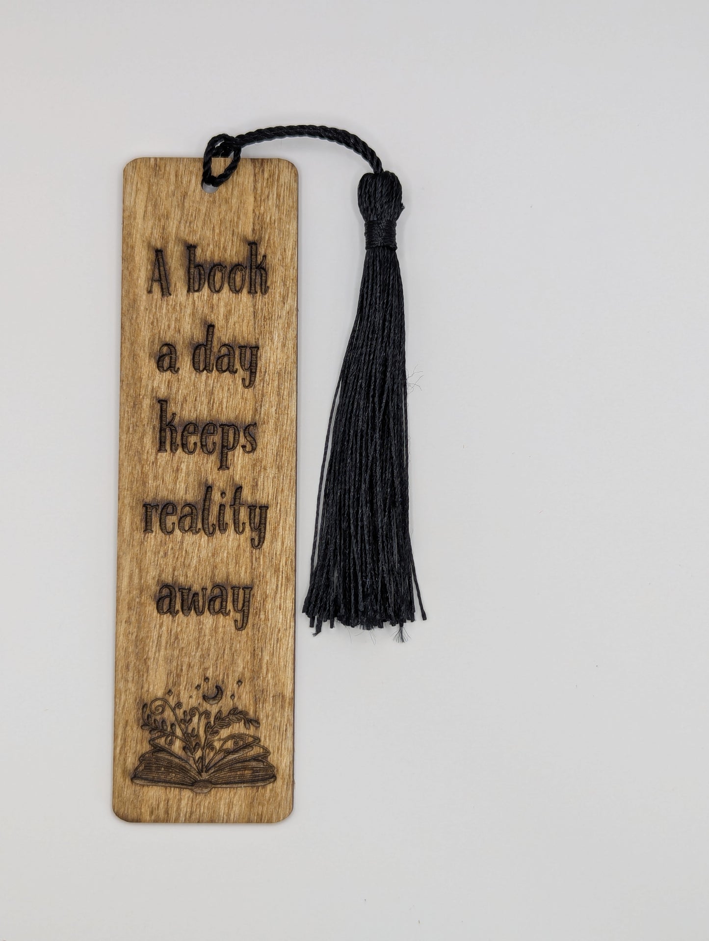 alt="Witty wooden bookmark engraved with ‘A book a day keeps reality away’"