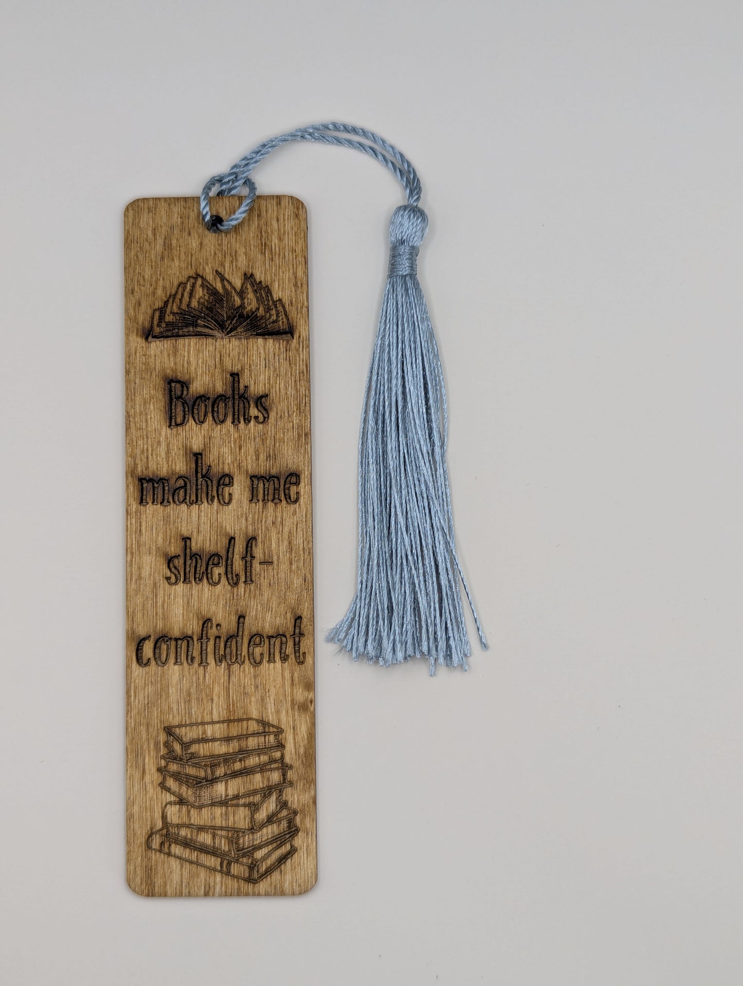 alt="Witty wooden bookmark engraved with ‘books make me shelf-confident’"