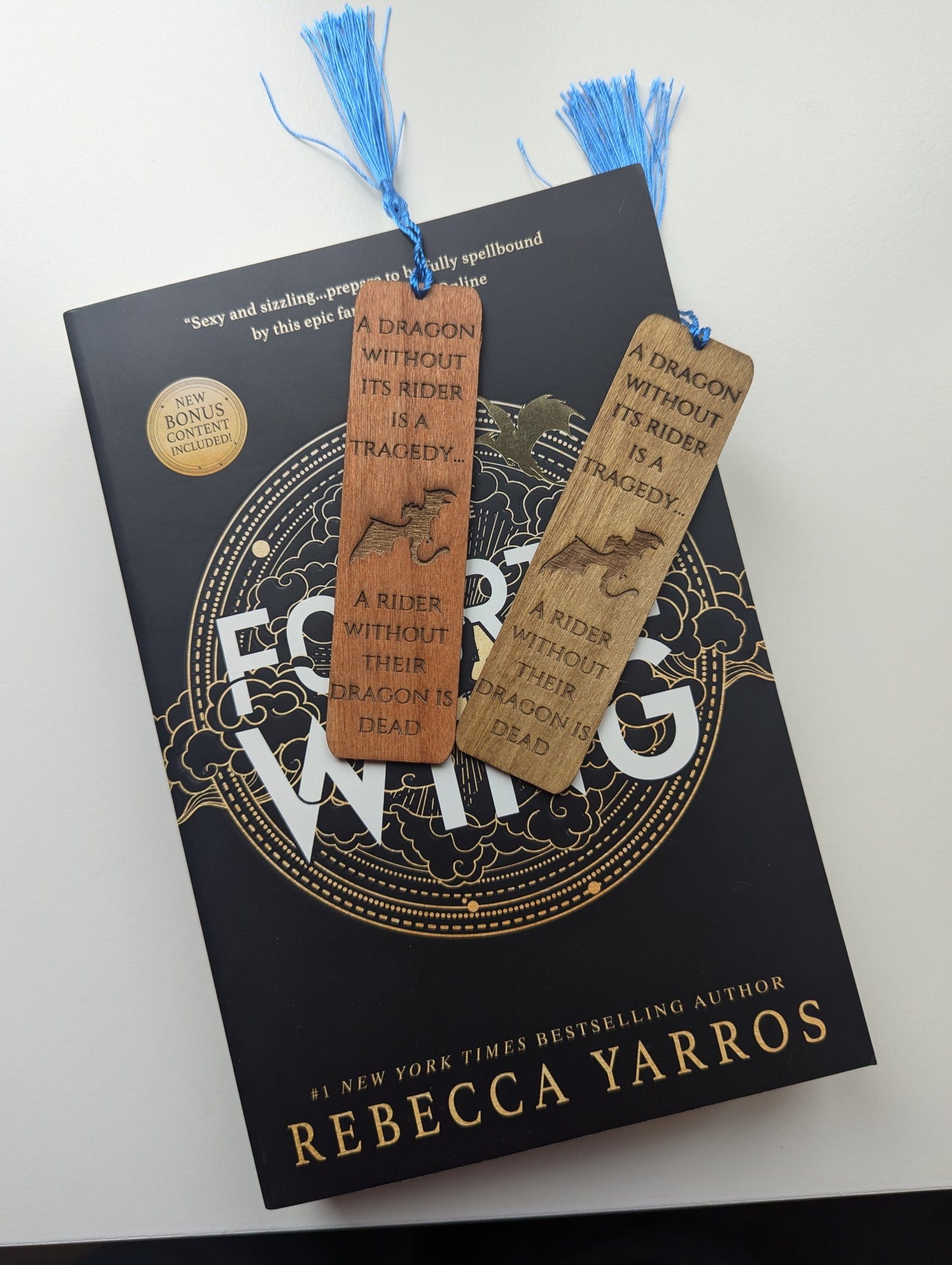 alt="Engraved wooden Fourth Wing bookmark with quote 'A Rider Without Its Dragon'"