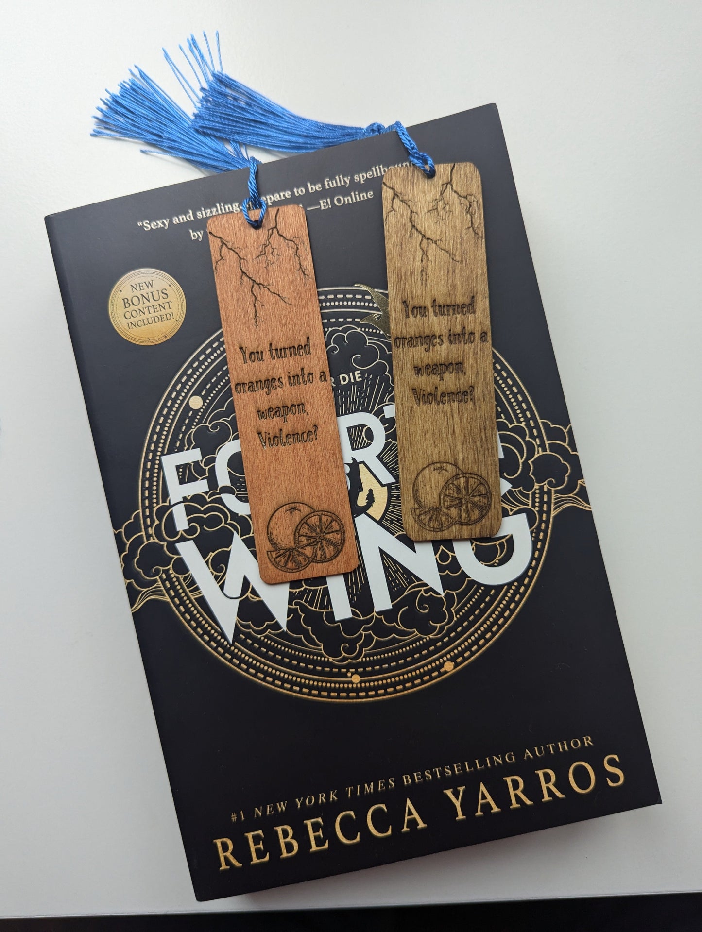 alt="Engraved wooden Fourth Wing bookmark with quote 'Oranges into a weapon'"