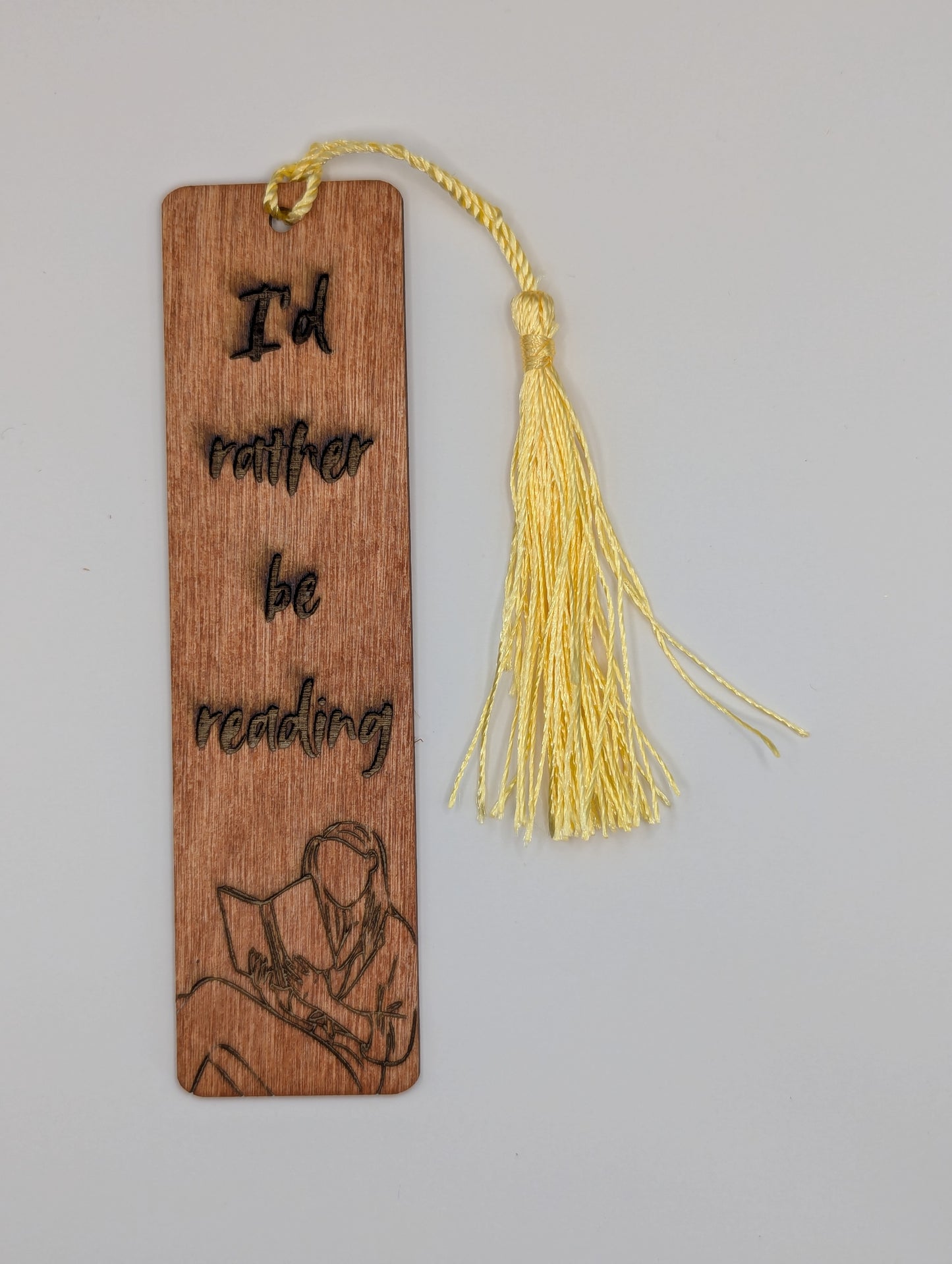alt="Witty wooden bookmark engraved with ‘Rather be Reading’"