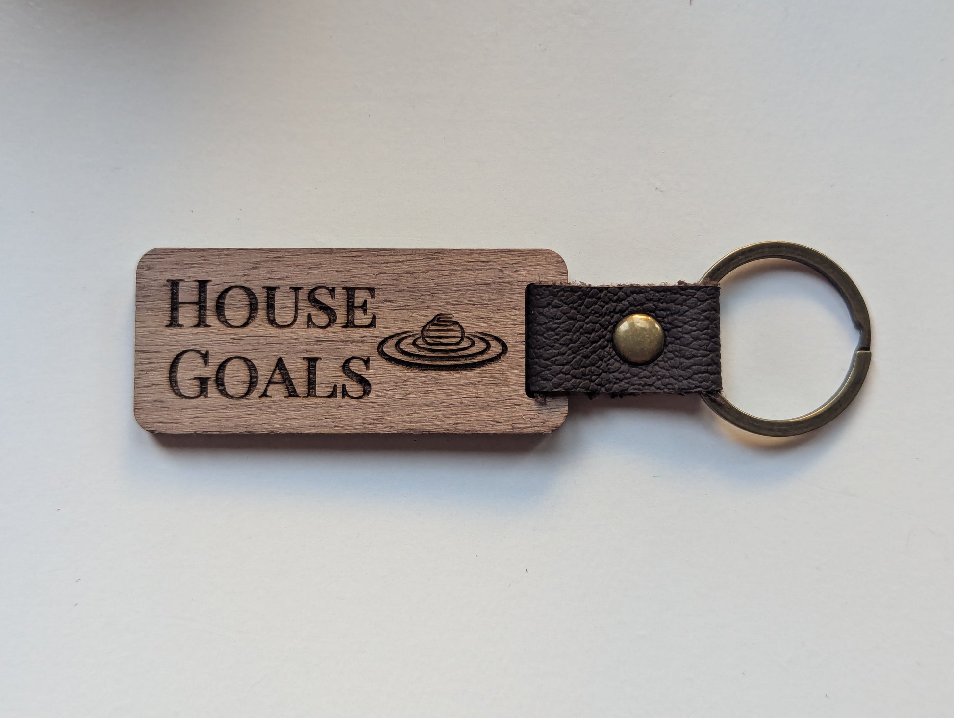 Wooden keychain with 'House Goals' engraving on a white background