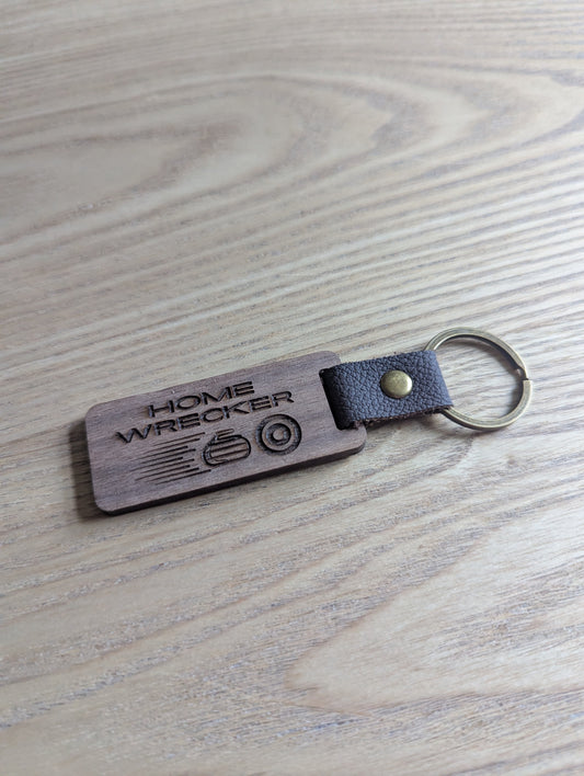 Keychain with 'Home Wrecker' engraving on a wooden surface